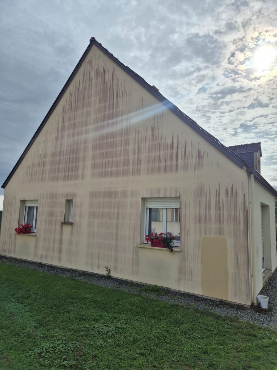 Pignon marqué par des coulures rouges avant nettoyage de façade