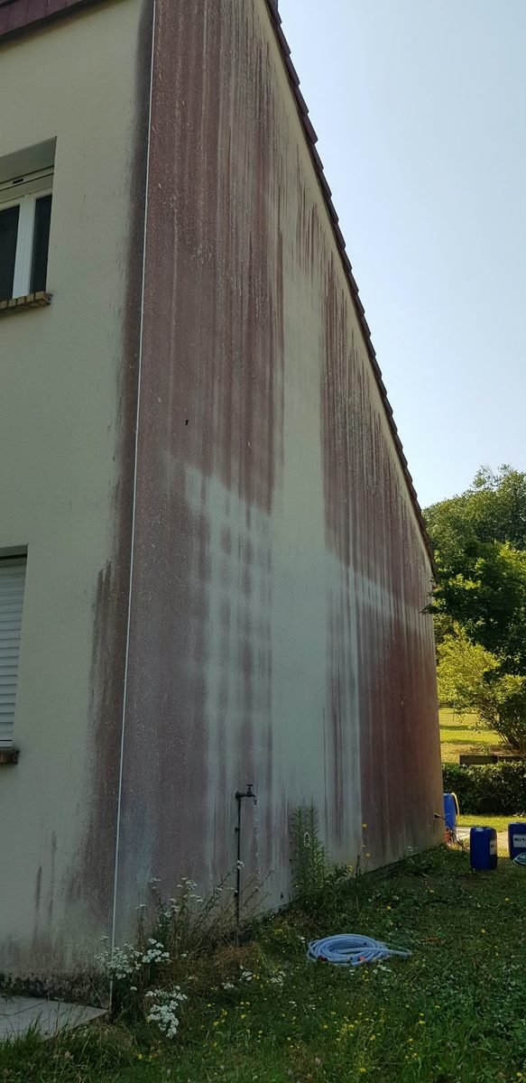 Grand pignon marqué de traînées rouges d'algues avant nettoyage