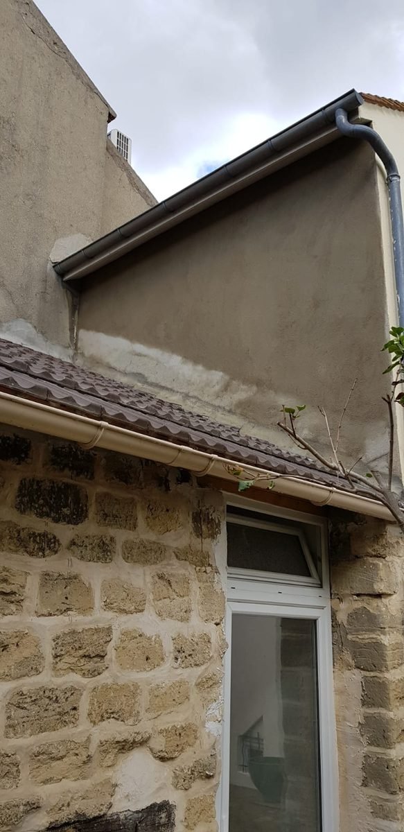 Pignon dont le nouvel enduit vient d'être posé, encore gris et humide
