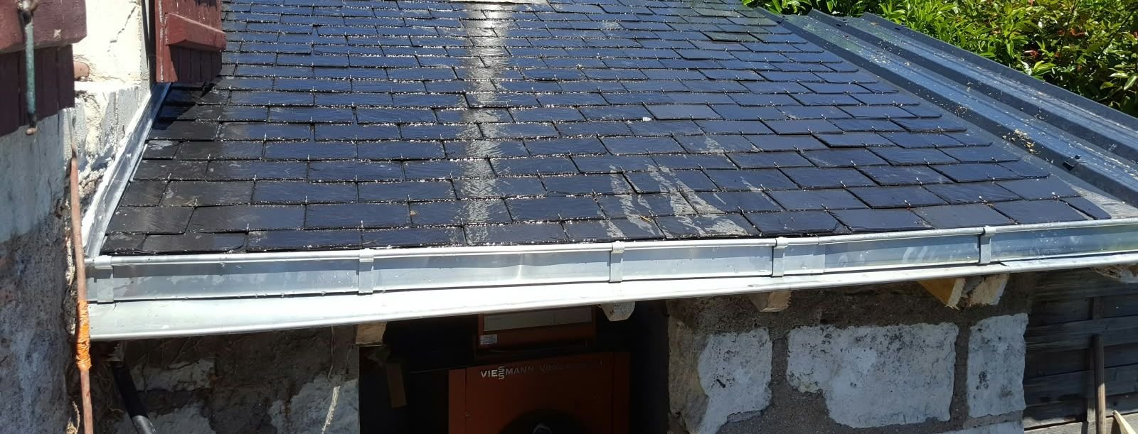 Gouttière en zinc neuve au bord d'une couverture en ardoise